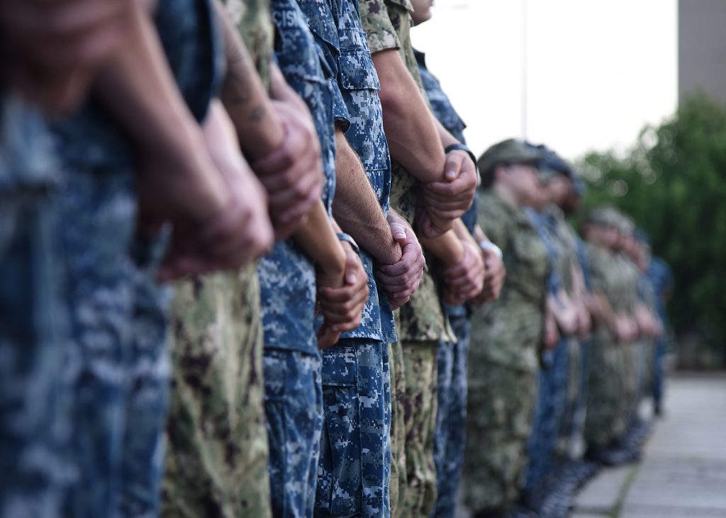 Line of military service members in various service uniforms.