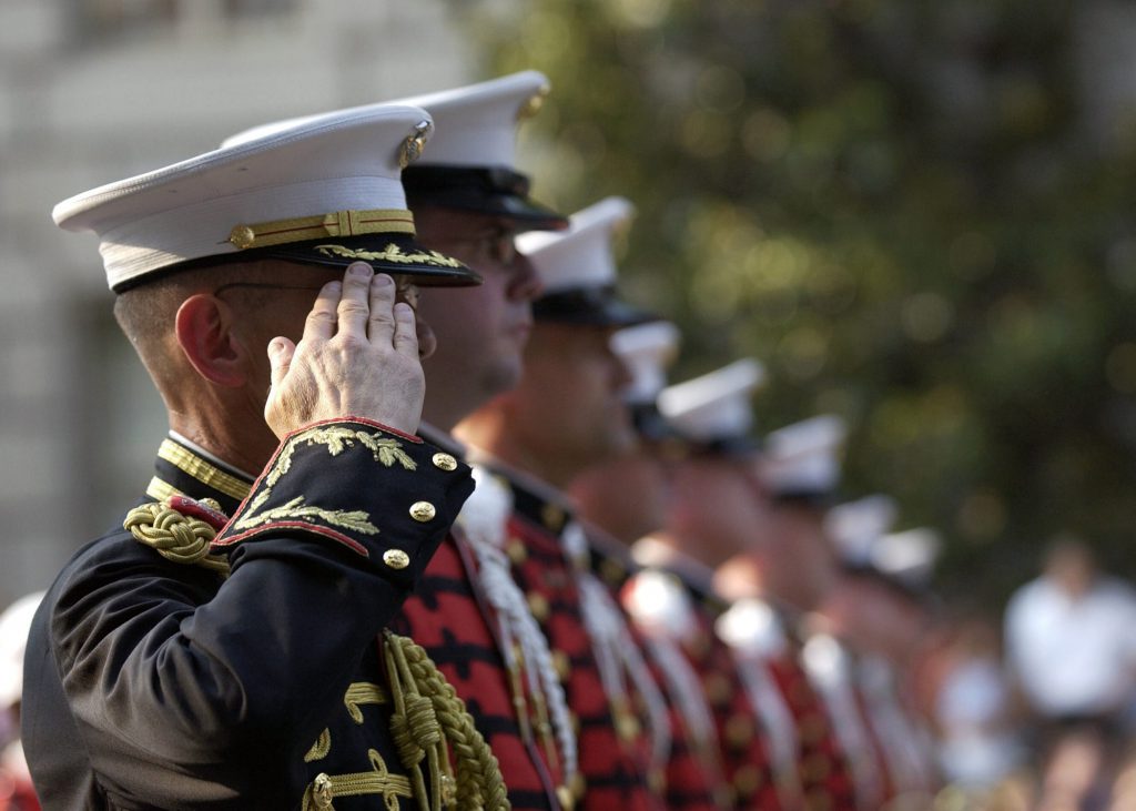 Military members in service dress - first one in line is rendering a salute.